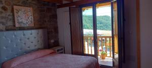 - une chambre avec un lit et une porte donnant sur un balcon dans l'établissement Casa Rural Pembes, à Pembes