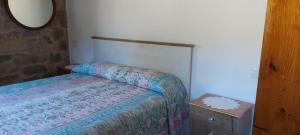 a small bedroom with a bed and a mirror at Casa Rural Pembes in Pembes
