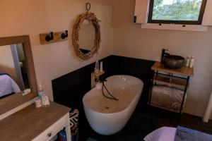y baño con bañera blanca y lavamanos. en The Surfers Bush Cabin en Jeffreys Bay