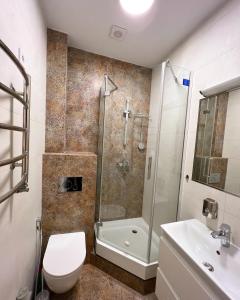 a bathroom with a shower and a toilet and a sink at VIP apartments in Lviv
