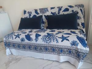 a bed with blue and white sheets and pillows at Casa Linguine in Petacciato