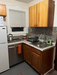 una cucina con lavandino e frigorifero bianco di Victorian Palace-Pecan Room a East Orange