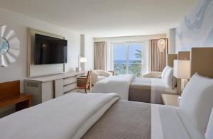 a hotel room with two beds and a television at The Westin Beach Resort & Spa at Frenchman's Reef in Frydendal