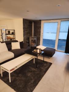 sala de estar con sofá y mesa en Appartement moderne avec terrasse et piscine à Châtel sur Bex en Bex