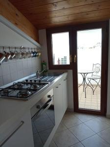 una cucina con piano cottura e vista su un patio di Accogliente appartamento mansardato vicino al mare a Tortoreto