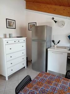 una cucina con frigorifero in acciaio inossidabile e cassettiera di Accogliente appartamento mansardato vicino al mare a Tortoreto