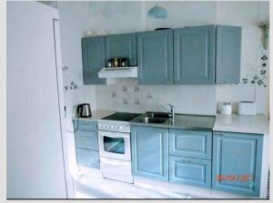 a blue kitchen with a sink and a stove at Lappilan B&B in Lappila