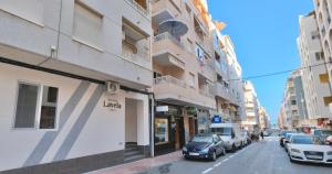 una calle con coches estacionados en el lateral de un edificio en Hostal Lavela, en Torrevieja