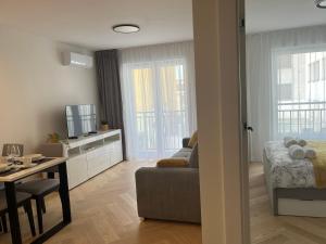 a living room with a couch and a tv and a table at Widok Kielce - Apartament przy Rynku in Kielce