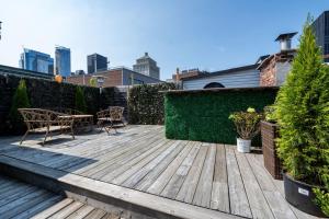 a wooden deck with two chairs and a table at Stunning Old Montreal Penthouse in Montreal