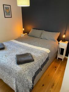 a bedroom with a large bed with a blanket at Stylish 2 bedroom apartment close to beaches in Fakenham