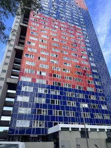 ein hohes Gebäude mit rotem und blauem Glas in der Unterkunft Ferienwohnungen in Köln2201 in Köln