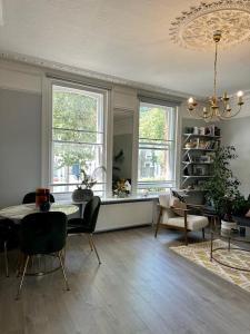 un soggiorno con tavolo, sedie e finestre di Design-led flat in Hampstead a Londra