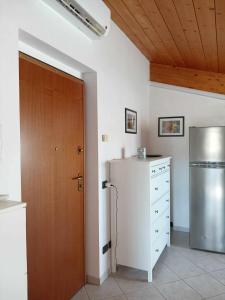 una cucina con frigorifero e porta in legno di Accogliente appartamento mansardato vicino al mare a Tortoreto