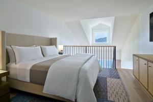 um quarto com uma cama grande e lençóis brancos em The Westin Beach Resort & Spa at Frenchman's Reef em Frydendal