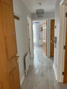 pasillo con paredes blancas, suelo de madera y puerta en Garden Avenue, en Portstewart