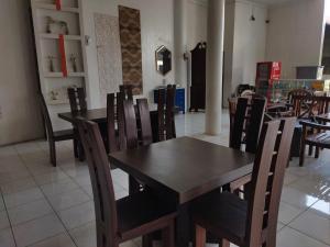 a dining room with a wooden table and chairs at Royal Kencana Hotel powered by Cocotel in Jepara