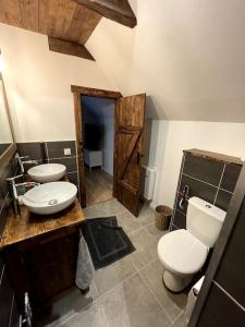 ein Bad mit 2 Waschbecken und einem WC in einem Zimmer in der Unterkunft Gîte du Pays-de-Salers, Cantal, classé 1* in Saint-Projet-de-Salers