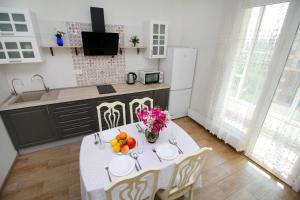 - une cuisine avec une table blanche et des fruits dans l'établissement Легенда 75, à Almaty