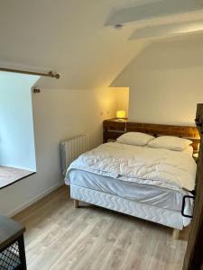Schlafzimmer mit einem Bett mit weißer Bettwäsche und Kissen in der Unterkunft Gîte du Pays-de-Salers, Cantal, classé 1* in Saint-Projet-de-Salers