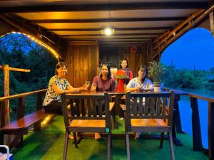 a group of women sitting at a table on a porch at Homestay Phong de Pêche in Ấp Tân Bình (1)