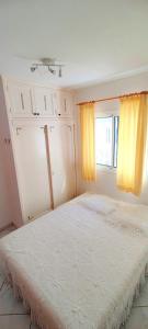a bedroom with a large bed with yellow curtains at Bungalow mit Meerblick in Costa Calma