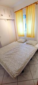 two beds in a room with yellow curtains at Bungalow mit Meerblick in Costa Calma +8 photos