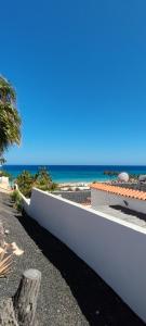 a white boat on the beach with the ocean in the background at Bungalow mit Meerblick in Costa Calma