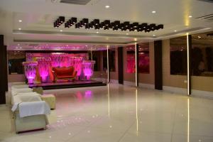 a lobby with a red chair and purple lighting at Hotel Kusum Palace in Gaya