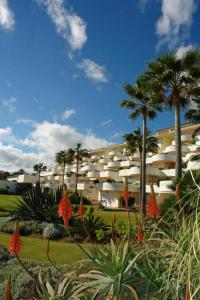 um grande edifício com palmeiras em frente em Spacious Stunning Views 2-Bed Apartment Estepona em Estepona