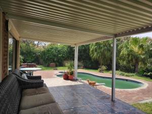 una pérgola de madera con sofá y un perro debajo en HomeAway Beach House en Port Edward