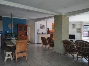 a living room with chairs and a table and a kitchen at HomeAway Beach House in Port Edward