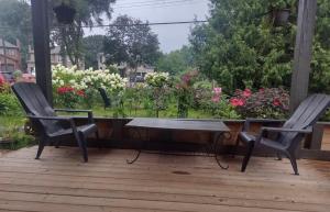 two chairs and a table on a deck with flowers at Luxury Suites at Military Trail in Toronto