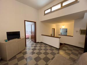 a living room with a television and a checkered floor at Casa vacanze La Dimora Allegra in Ladispoli
