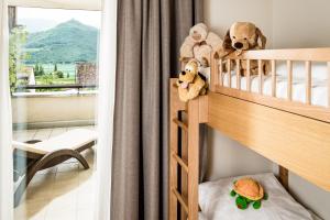 a bunk bed with stuffed animals on it in a room at Hotel Hasslhof in Caldaro