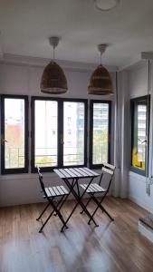 a table and two chairs in a room with windows at Hostal Zaragoza Centro in Zaragoza