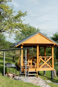 a wooden pavilion with a grill in the grass at Rest houses FORUMS in Oriv