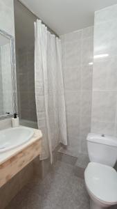 a bathroom with a toilet and a tub and a sink at Hostal Zaragoza Centro in Zaragoza