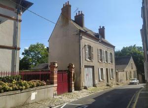 una casa con una puerta roja en una calle en Ô Bulles de Loire, Châteauneuf-sur-Loire, en Châteauneuf-sur-Loire