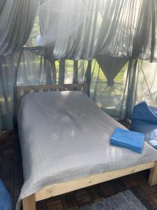 łóżko w namiocie z niebieskim ręcznikiem w obiekcie Pušų gaudyklė w mieście Ginučiai