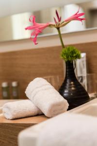 a pink flower in a vase next to a sink at Living Apartments Ludwigshafen in Ludwigshafen am Rhein