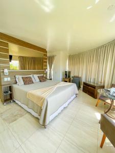 a large bedroom with a large bed and a couch at La Plage Residence in Garopaba
