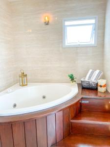 a bath tub in a bathroom with a window at La Plage Residence in Garopaba +18 photos