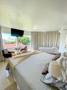 um quarto grande com uma cama grande e uma mesa em La Plage Residence em Garopaba