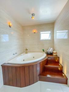 a large bath tub in a bathroom with stairs at La Plage Residence in Garopaba