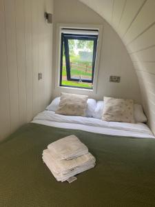Cama en habitación pequeña con ventana en Kildare countryside pods en Kildare