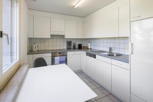 a kitchen with white cabinets and a sink at habu bei Plättli Zoo cosy stay in Frauenfeld