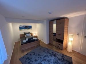 1 dormitorio con 1 cama, armario y alfombra en Ferienwohnung zur Fröhlichkeit, en Oberaltertheim