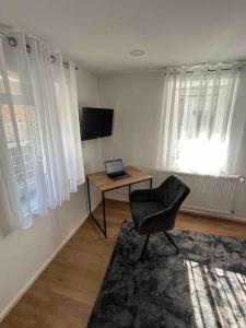 a room with a desk with a laptop and a chair at Ferienwohnung zur Fröhlichkeit in Oberaltertheim