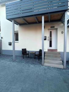 a building with a blue roof and a table and chairs at Ferienwohnung zur Fröhlichkeit in Oberaltertheim